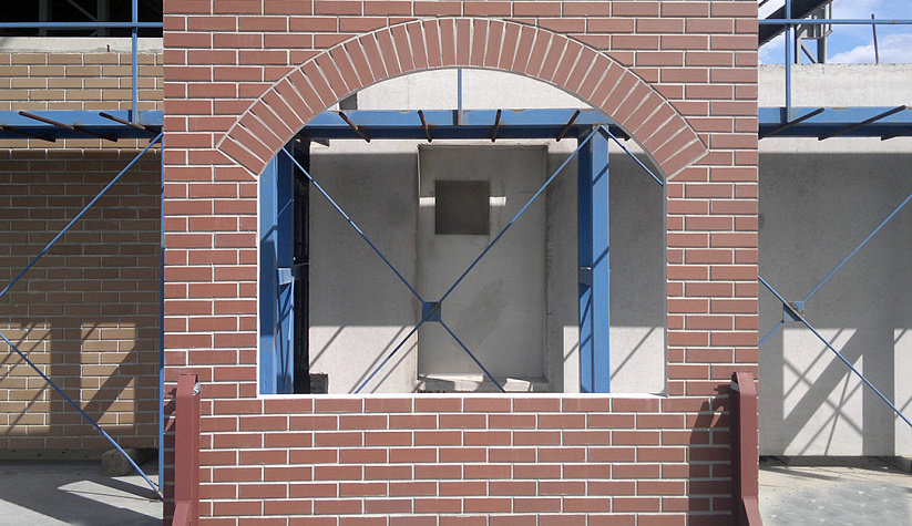 Фасад с арочным оконным проёмом облицованный клинкерной плиткой 